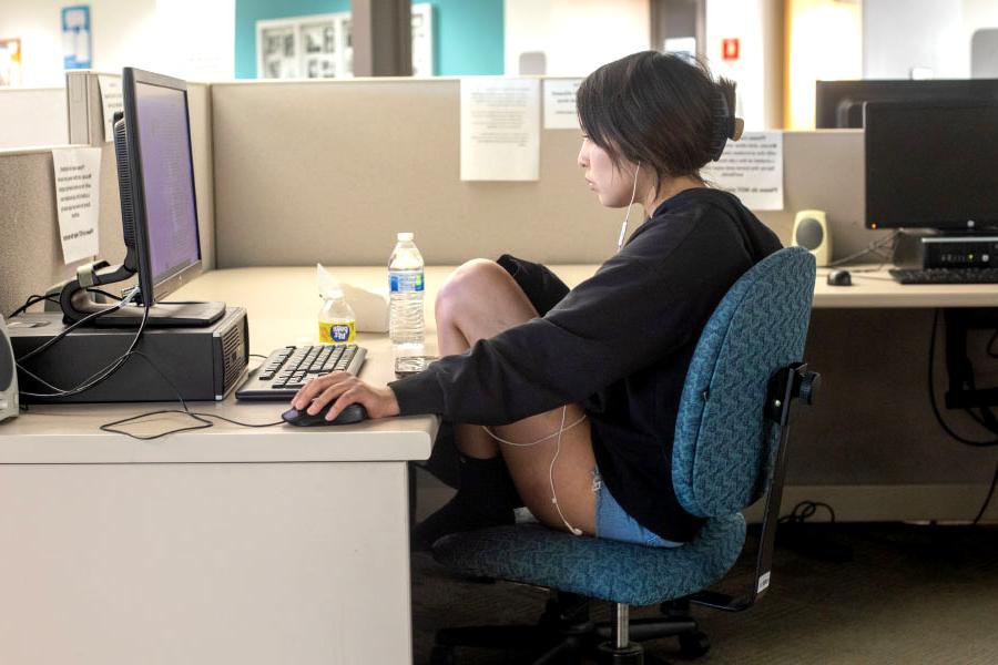 女学生戴着耳机坐在桌前玩电脑